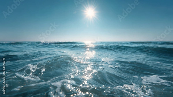 Fototapeta Calm sea with gentle waves and bright sunlight reflecting on water, creating serene and peaceful atmosphere