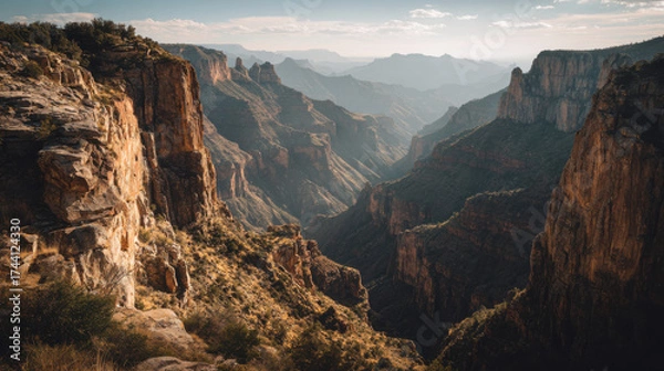 Fototapeta Sunlit canyon cliffs with dramatic shadows create breathtaking landscape view
