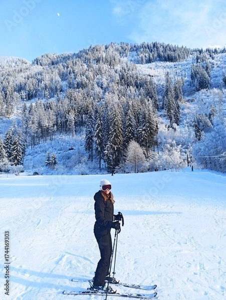 Fototapeta Athlete skiing on the slope on vacation in the mountains. Fashion ski vacation. Fashion girl skiing in the Alps. Model posing with frozen forest background. Landscape of ski slopes. Ski resort. Blog.