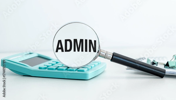 Fototapeta A calculator sits on a table next to a magnifying glass. The magnifying glass is focused on the word Admin,