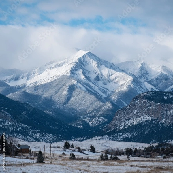 Fototapeta Mountain landscape of snow-capped mountains in the mist.
