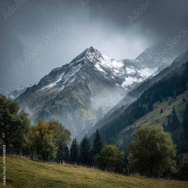 Fototapeta Mountain landscape of snow-capped mountains in the mist.
