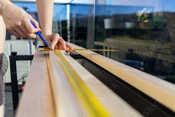 Fototapeta Wide angle of woman carpenter work on a wood project in home balcony. Self DIY project.