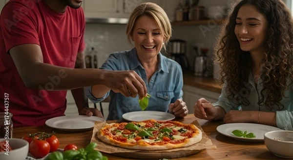 Fototapeta A family adding fresh basil to a homemade pizza in a bright kitchen with tomatoes and white plates