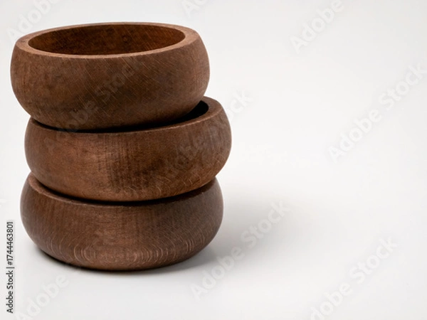 Fototapeta Stack of three round wooden bowls on white background minimalist composition