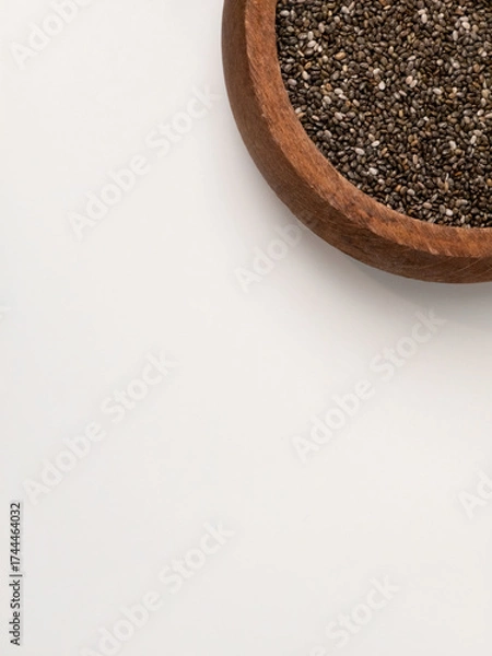 Fototapeta Chia seeds in wooden bowl on white background with copy space