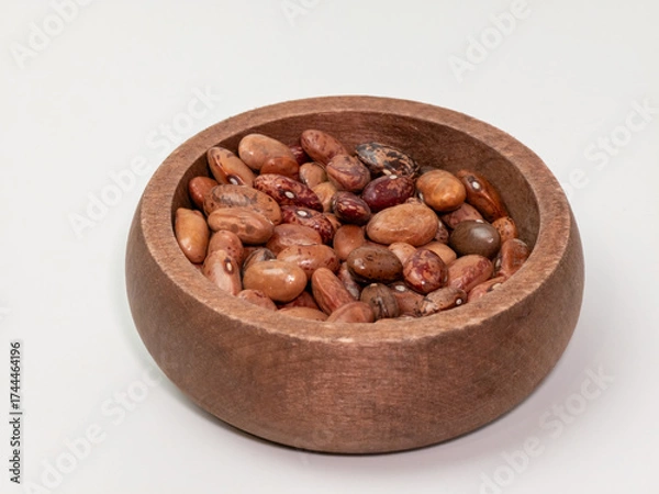 Fototapeta Assorted dried beans in a rustic wooden bowl on white background