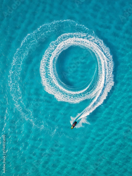 Fototapeta A jet ski moves swiftly in a circular pattern, leaving behind a beautiful wake in the turquoise waters of a tropical beach on a sunny day. Generative AI.