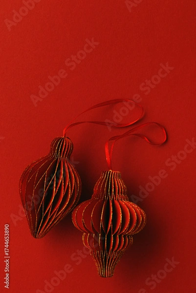 Fototapeta Festive Red Paper Christmas Ornaments,  hanging red flashlight or lantern, honeycomb scandinavian decor on red background, minimal monochrome photo, festive holiday mood, top view, copy space