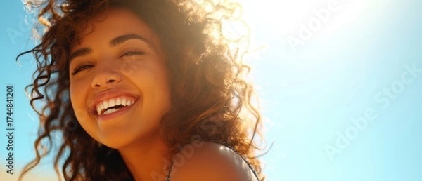 Obraz The woman laughing in warm sunlight with curly hair and a radiant smile