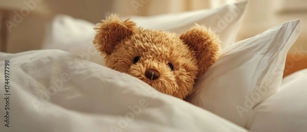 Obraz The Teddy Bear Snuggled in Cozy White Bed Linen at Morning Light