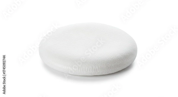 Fototapeta A fluffy white circular pad rests on a plain white surface casting a soft shadow