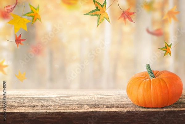 Fototapeta wooden table and a blurry autumn background.  background with autumn leaves and a beautiful pumpkin, product presentation.