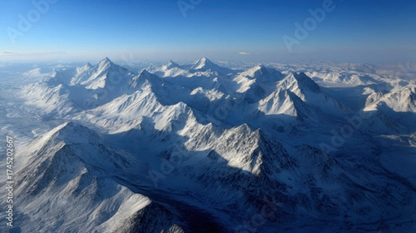 Fototapeta The sky is blue and the mountains are covered in snow