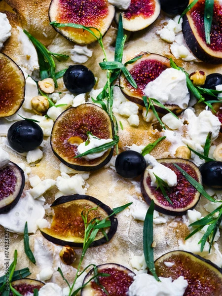 Fototapeta Delicious fig and cheese pizza topped with herbs and nuts served fresh