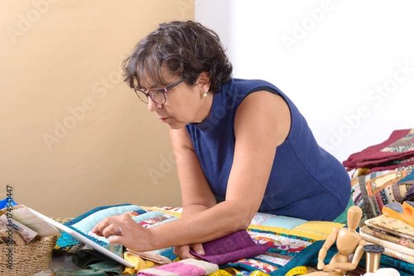Fototapeta beautiful mature seamstress using tablet computer