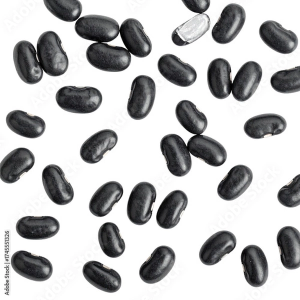 Fototapeta Overhead shot of scattered glossy black beans on a stark black background, some slightly out of focus