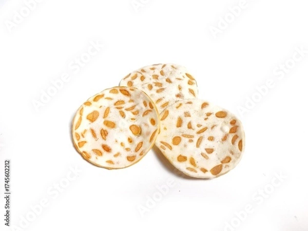 Fototapeta Keripik Tempe or Tempeh Chips isolated on white background with copy space. Traditional Indonesian food are made from soybeans mixed with rice flour then sliced ​​thinly. Suitable fot design element.