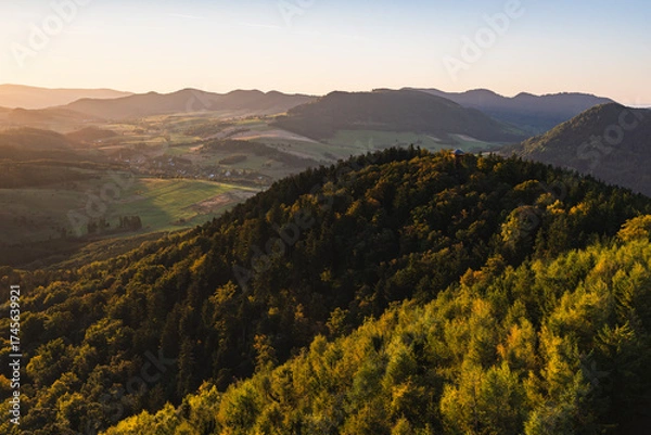 Fototapeta A beautiful mountain landscape seen from the new observation tower on Dzikowiec Wielki. Sunrise in the town of Boguszow Gorce. The Kamienne and Walbrzych Mountains.