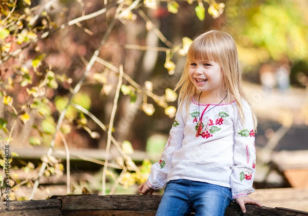 Fototapeta Joyful Girl Enjoying an Autumn Day Outdoors, Surrounded by Vibrant Fall Colors and the Spirit of Halloween in October