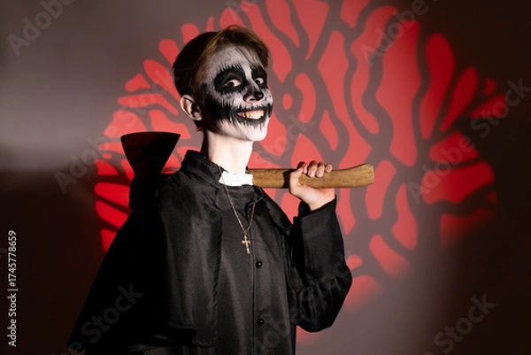 Fototapeta a young guy dressed up in a Halloween costume with an axe.