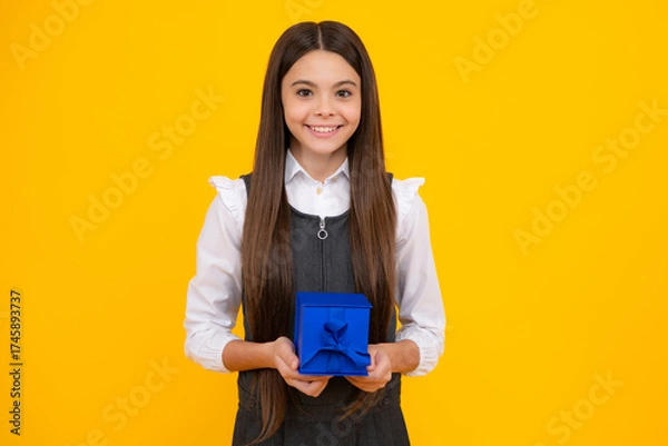 Fototapeta Teenager child with gift box, studio isolated background. Present for birthday, Valentines day, New Year or Christmas. Kid hold present box with gift ribbon bow.