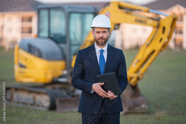 Fototapeta Worker in suit and helmet. Investor civil engineer, construction manager. Construction building developer at a construction site. Successful architect. Handsome hispanic builder man in suit.