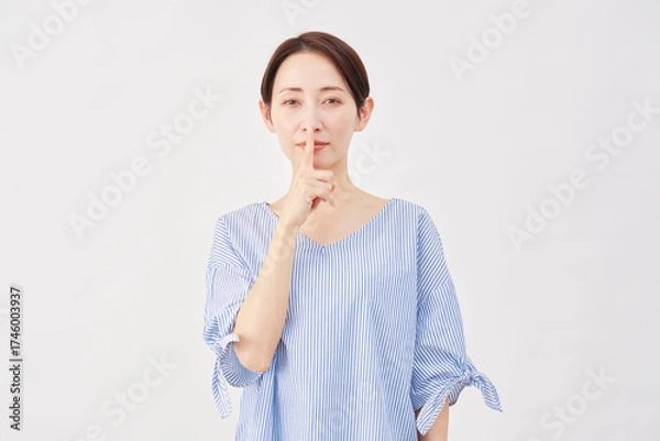Fototapeta 女性　ミドルエイジ　内緒のジェスチャー　白背景