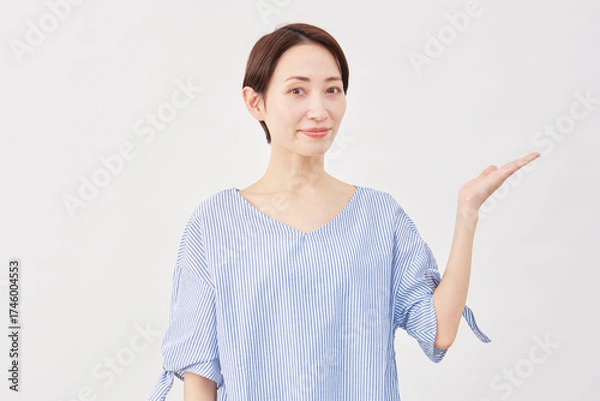 Fototapeta 女性　ミドルエイジ　手のひらで右を指す　白背景