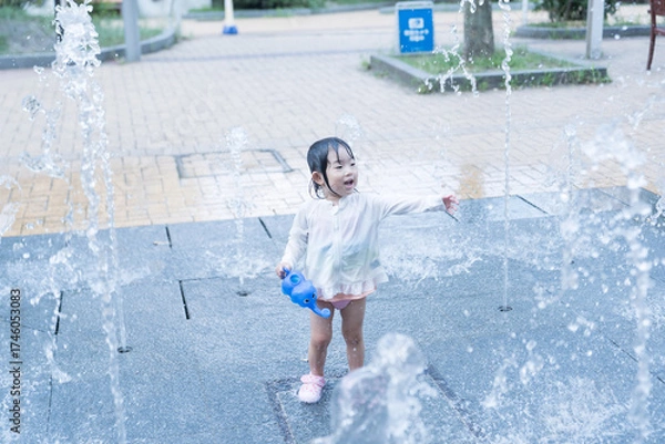 Fototapeta マンション広場の噴水で遊ぶ日本人の幼児
