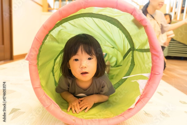 Fototapeta トンネルの遊具で遊ぶ女の子の幼児