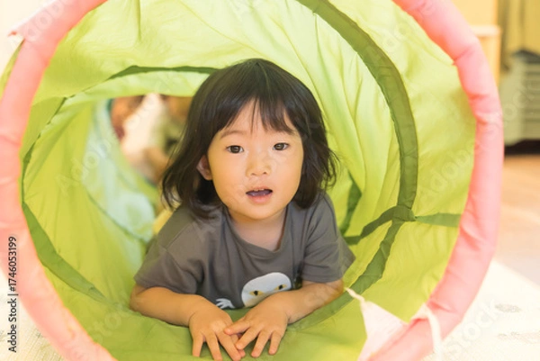 Fototapeta トンネルの遊具で遊ぶ女の子の幼児