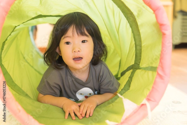 Fototapeta トンネルの遊具で遊ぶ女の子の幼児