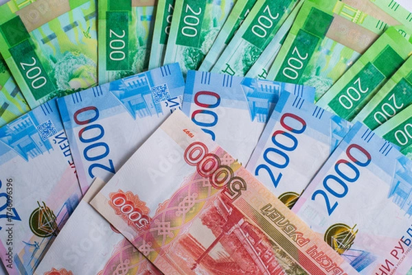 Fototapeta different denominations Russian banknotes are spread out on flat surface. image showcases colorful 200, 2000 and 5000 ruble notes, highlighting their unique designs. close up.