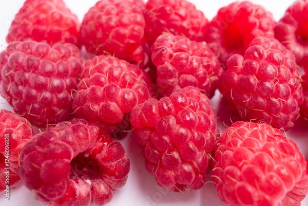 Fototapeta juicy raspberries are piled together in neat cluster, their rich red hue and delicate texture. perfect for snacking or adding to dishes. close up.
