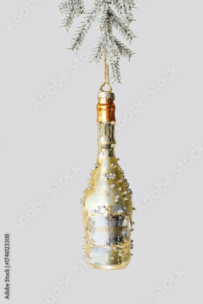 Fototapeta Minimal creative aesthetic view of Champagne bottle Christmas ornament hanging on fir tree branch. New Year golden toy as sparkling wine. Festive Winter holiday still life. Concept of celebration.