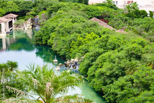 Obraz 爽やかな南国の鮮やかなヤシが映える高級リゾートホテルのラグーン・中庭・池と滝（沖縄県宮古島市）
