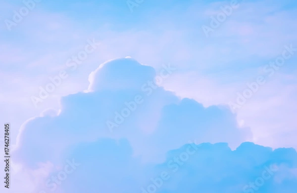 Fototapeta Fluffy white clouds drift across a brilliant blue sky, casting soft shadows that evoke a sense of calm and endless possibility.