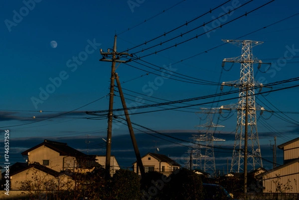 Obraz transmission steel tower carries high-voltage lines to the area at dusk in the Saitama countryside, Japan.