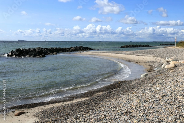 Fototapeta Landscape photo with a view of a bay of sea, a pebble beach and a blue sky with clouds at Cape Grenen, in Skagen, northern Denmark