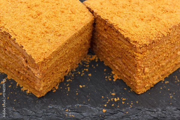 Fototapeta Homemade layered sweet cake with crumbs and cream, closeup view with selective focus.