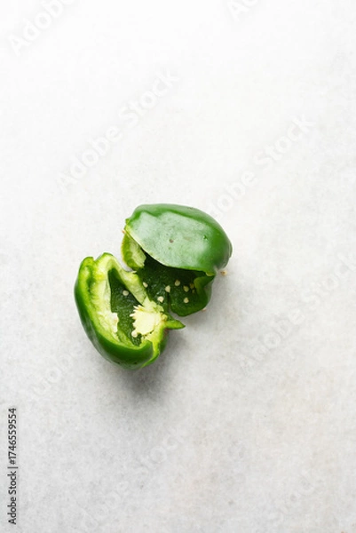 Fototapeta Overhead view of green bell peppers being sliced on a marble countertop, top view of green bell peppers