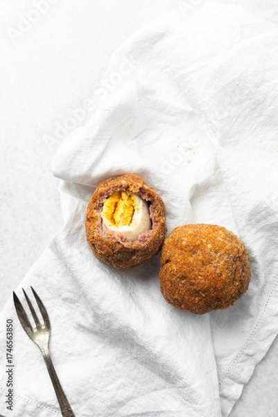 Fototapeta Overhead view of fried scotch eggs on white napkin