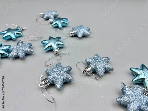 Obraz Blue Christmas star decorations scattered on a light surface, top view