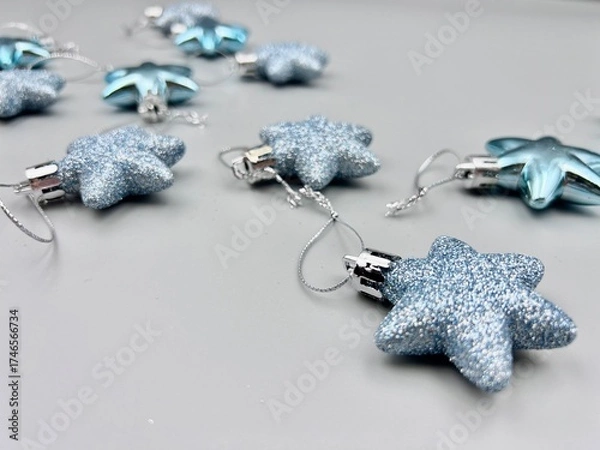 Obraz Blue Christmas star decorations scattered on a light surface, top view