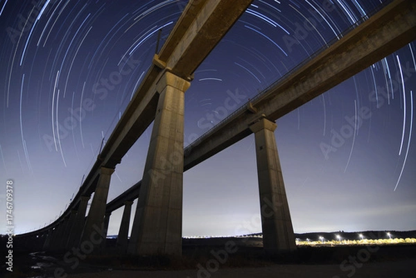 Obraz Parallel Railway Bridges at Night with Star Trails Around Polaris