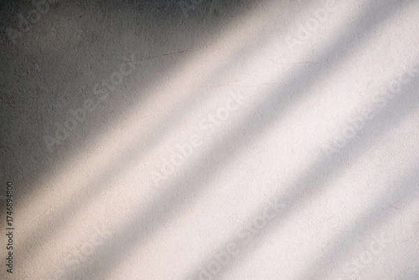 Fototapeta Diagonal shadows stretch across a textured wall, creating an interplay of light and shadow. The simplicity adds a calming effect.AI generated.