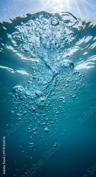 Obraz Bubbles rising in blue water towards a sunlit surface, ideal for spa ads, nature concepts, underwater themes, and relaxation designs.