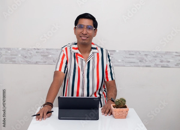 Fototapeta Joven sonriente viendo  su tablet de estudio
