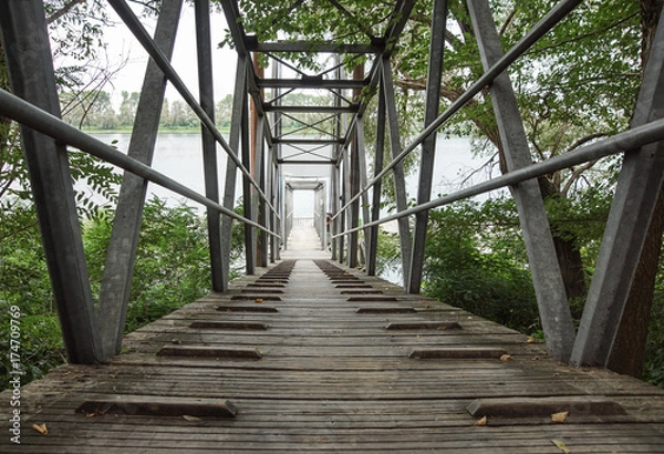 Fototapeta Wood and metal footbridge on the river in autumn
